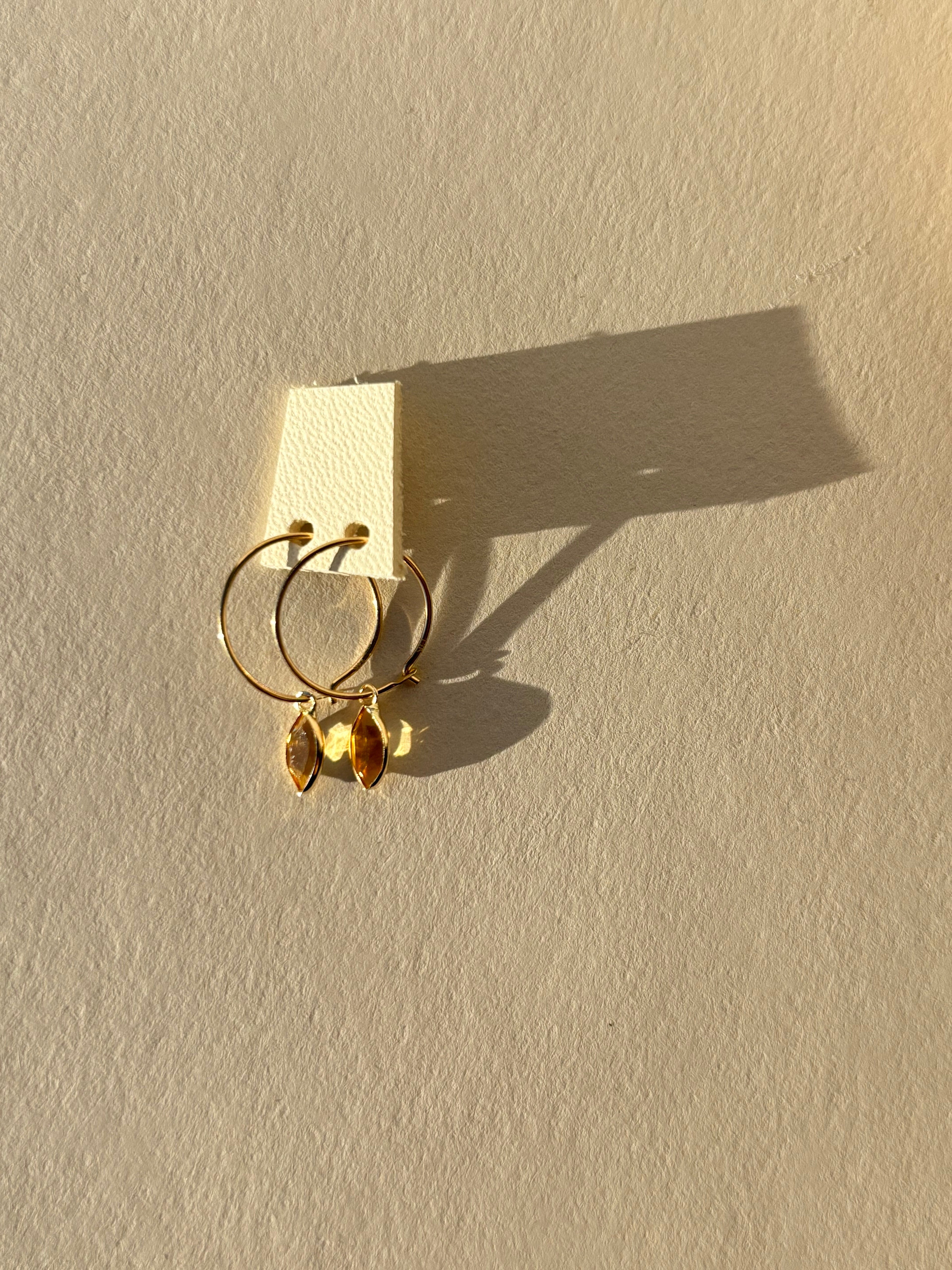 pair of solid gold hoop earrings with citrine charm earrings