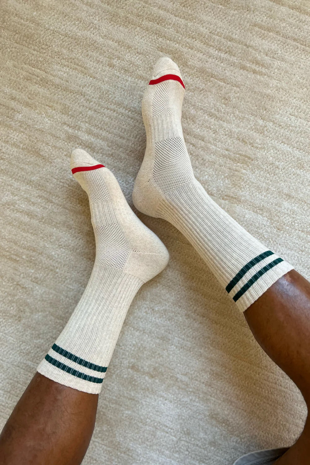 man in crew socks with red stripe on the toe and two green stripes on the calf