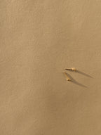 Pair of 2mm 14k solid gold ball stud earrings displayed on a neutral background