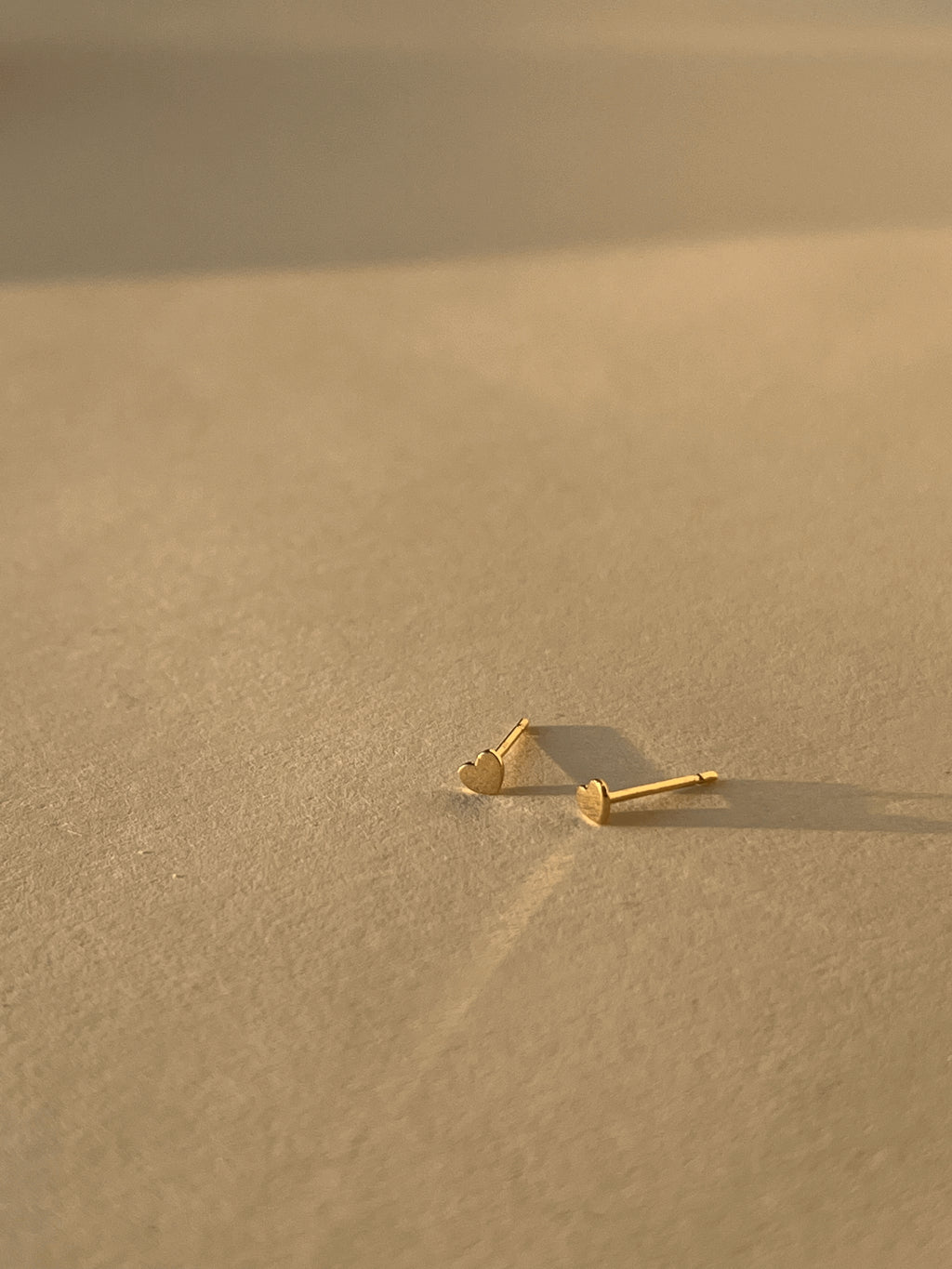 Close-up product shot of the 3mm heart studs on a neutral surface