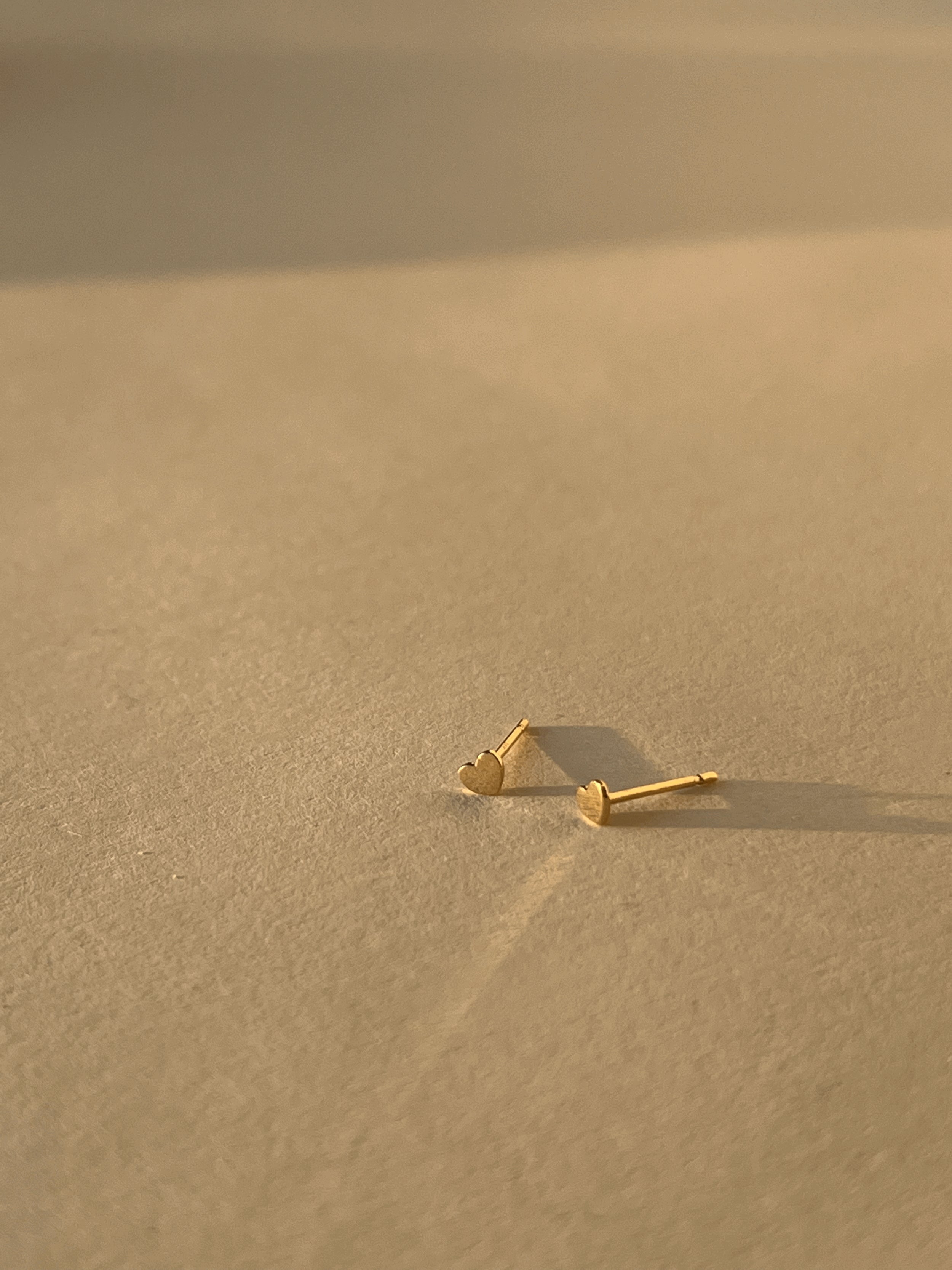 Close-up product shot of the 3mm heart studs on a neutral surface
