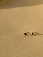 Pair of Tiny Skull Stud Earrings front faced, showcasing gold skull shape and black enamel eye detailing