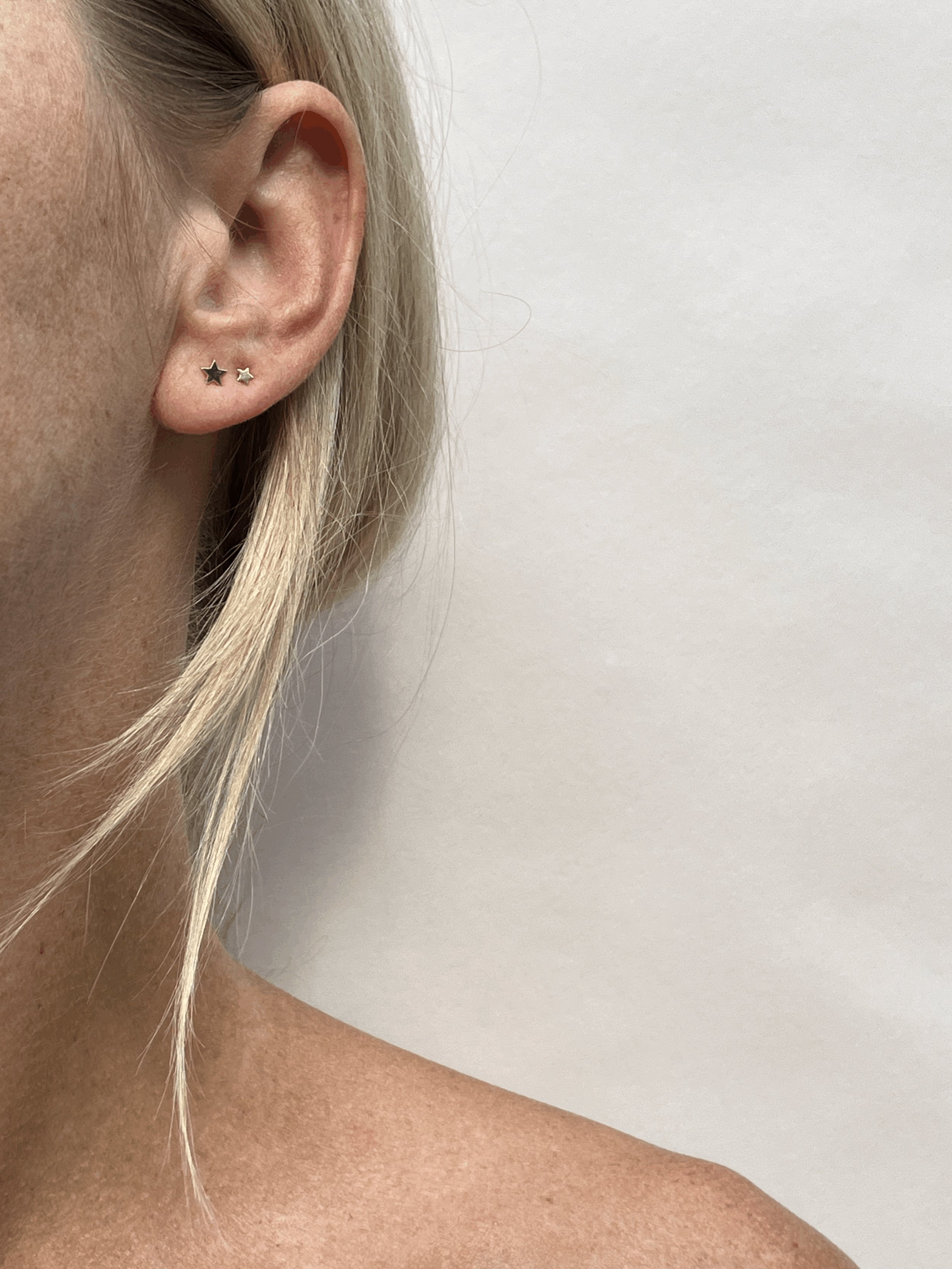Model wearing the 4mm star stud in her first ear piercing and the 3mm star stud in her second piercing