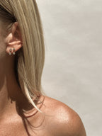 Model wearing Thalken’s 3mm gold-filled cubic zirconia stud and drop earrings in first and second piercings for a layered minimalist look