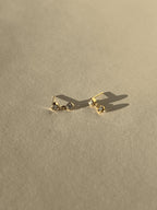 Product shot of Thalken’s 3mm gold-filled cubic zirconia stud and drop earrings on a neutral background, showing pair layout