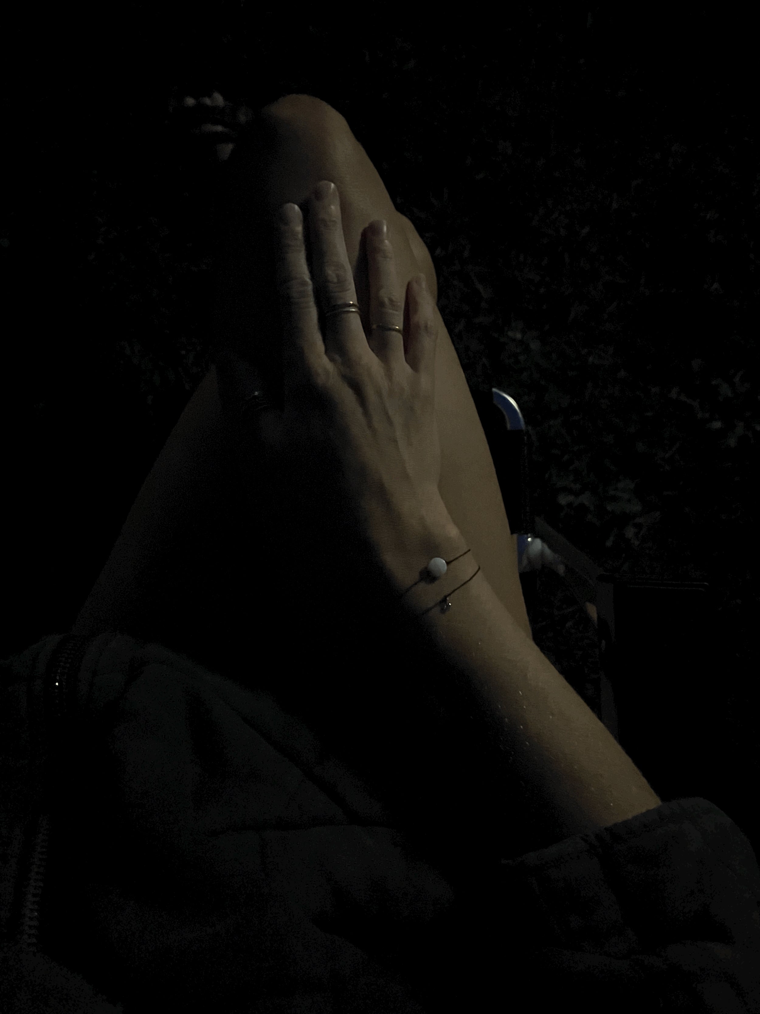 Nighttime bird’s-eye view of model in white pajama shorts showing the Thalken® sparkle mantra bracelet with the Moon Charged bracelet