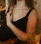 Model wearing an 18-inch yellow gold-filled charm necklace with two small 7mm disc charms