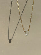 Light blue aquamarine stone necklace in yellow gold-filled suspended in air with sparkly light