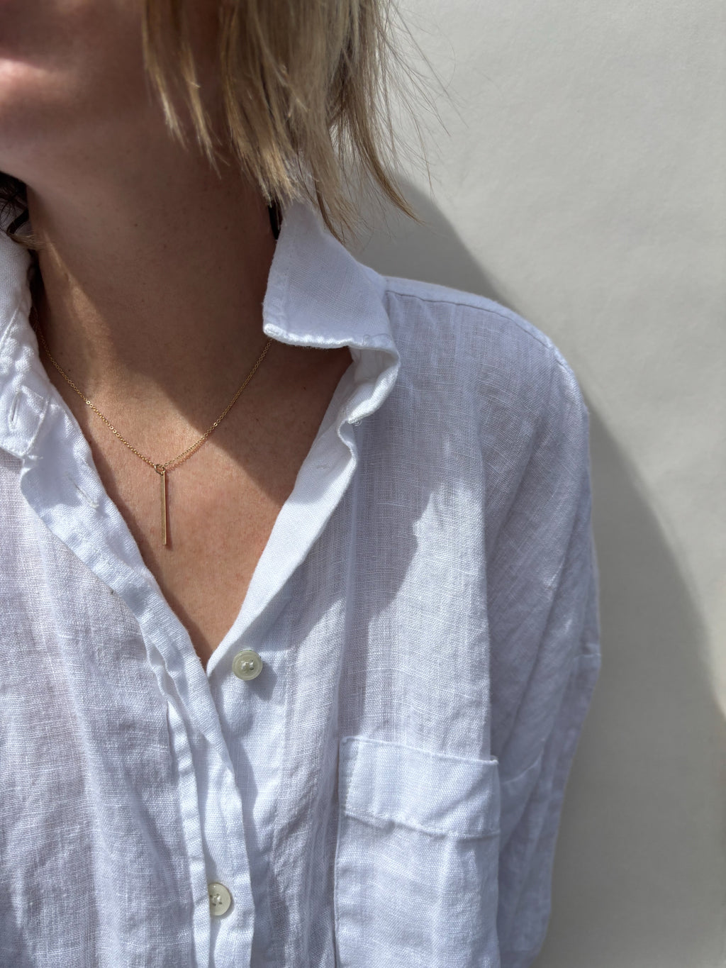 Model wearing minimalist Thalken bar necklace in the 16" option