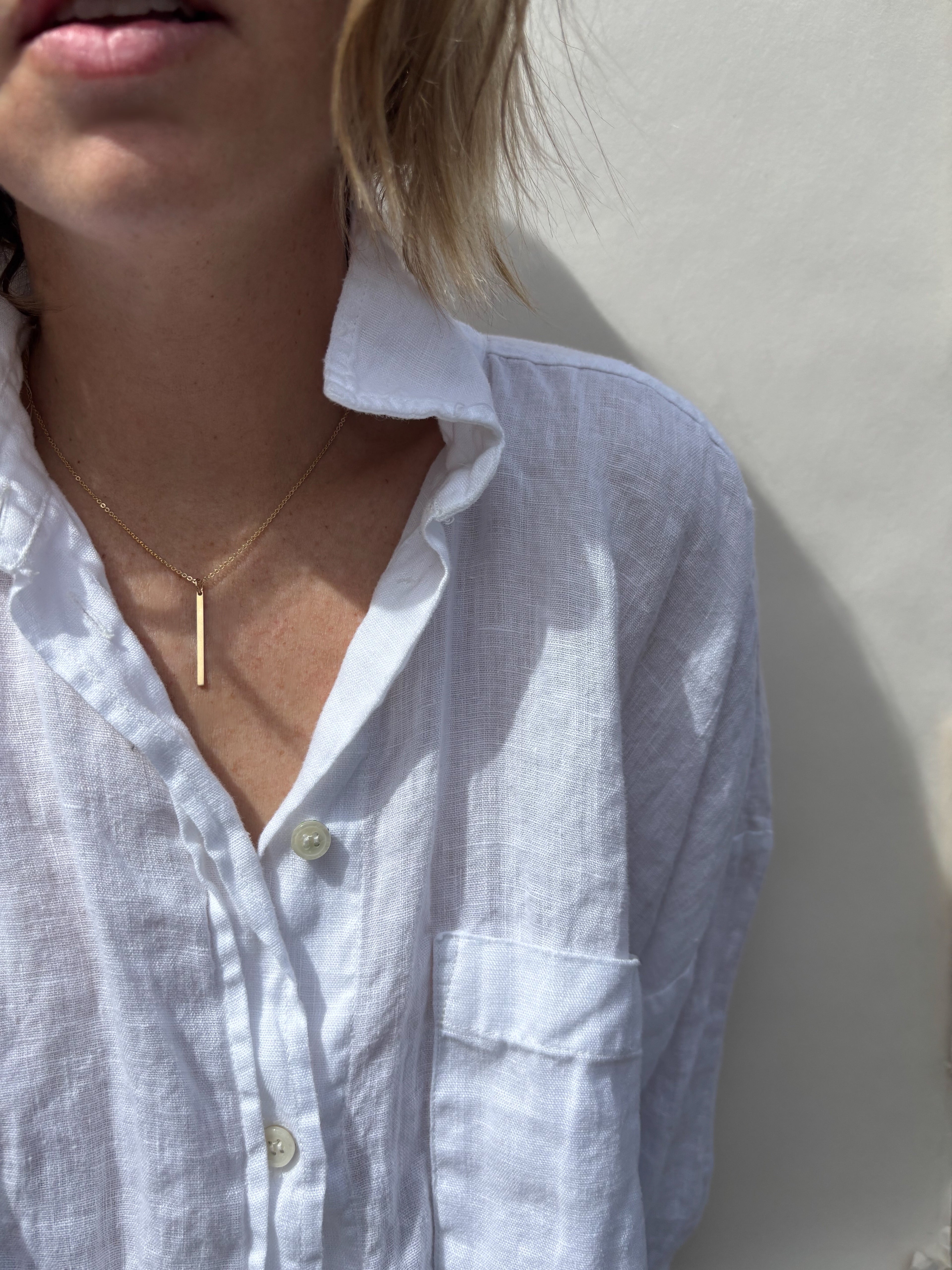 Model wearing minimalist Thalken bar necklace in the 16" option