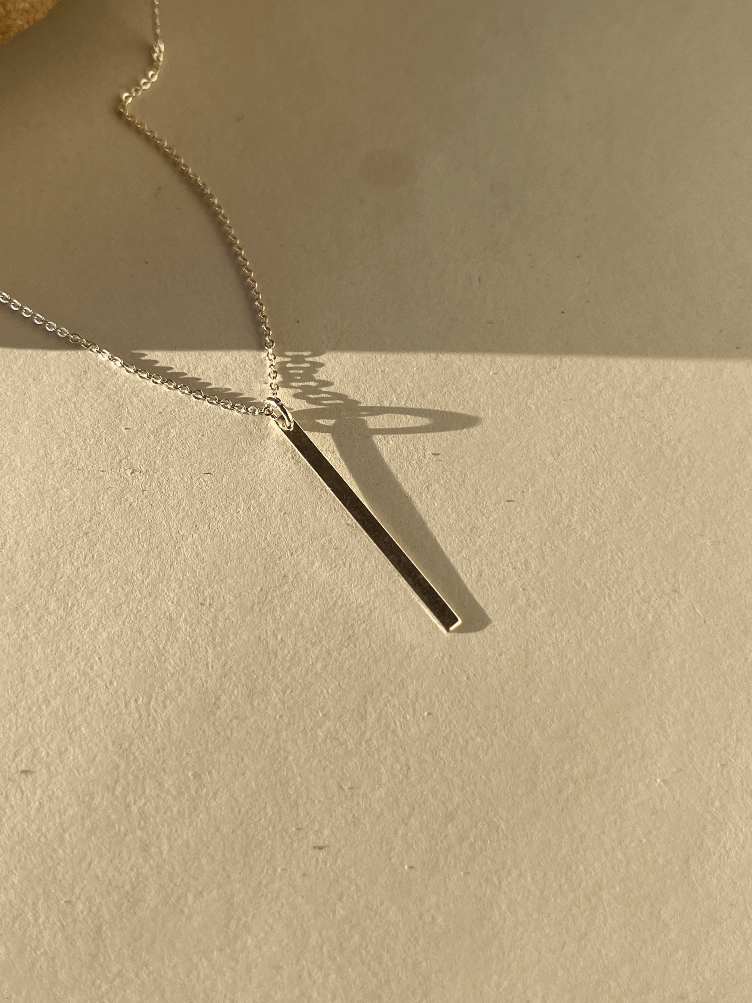 Sterling silver Bar Necklace product shot on neutral paper background