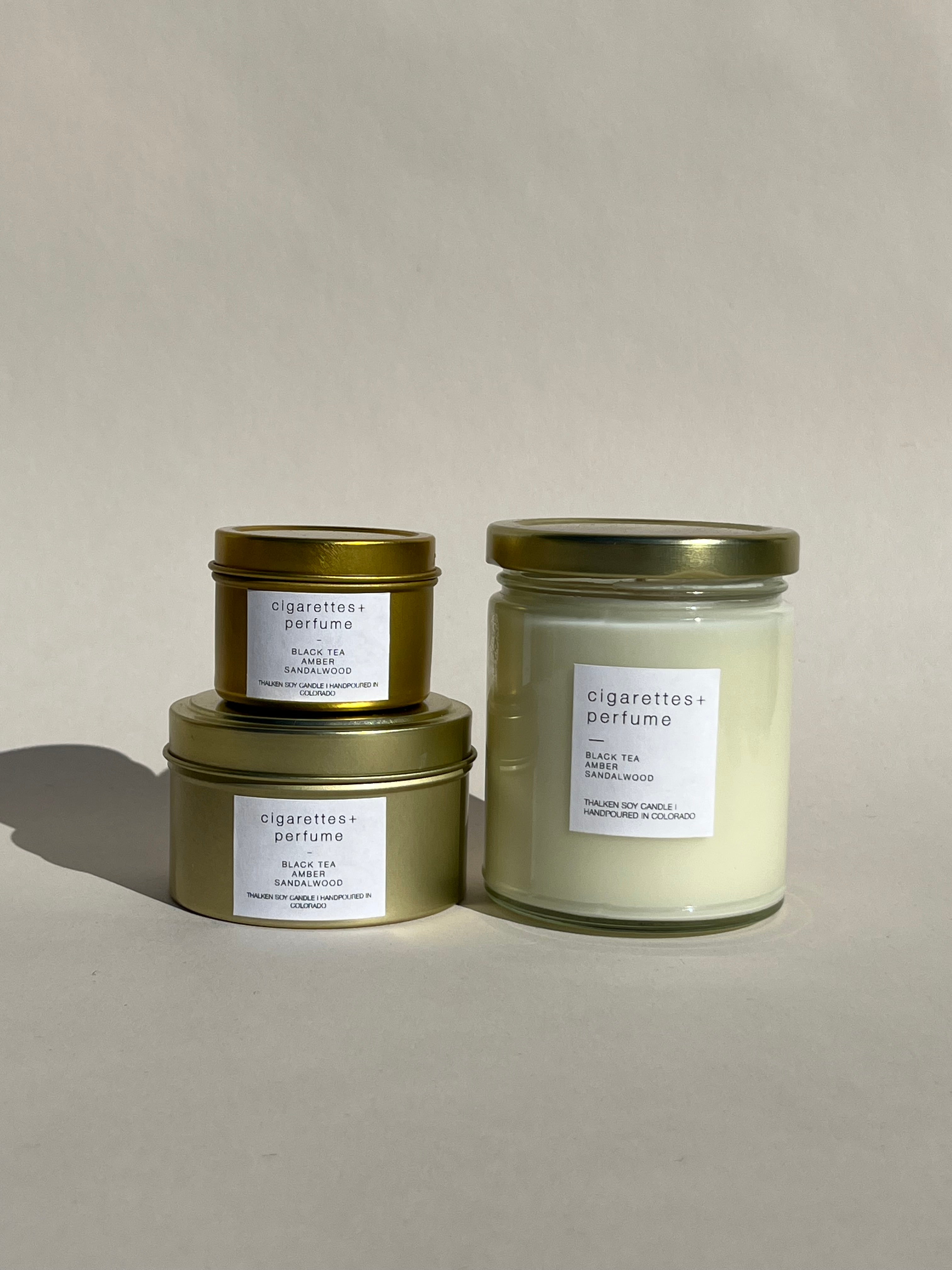 Thalken® Cigarettes + Perfume candle in three sizes — 2oz and 6oz gold tins and 8oz soft-glow glass jar. Scent profile: sultry, musky, and alluring with notes of black tea, amber, and sandalwood
