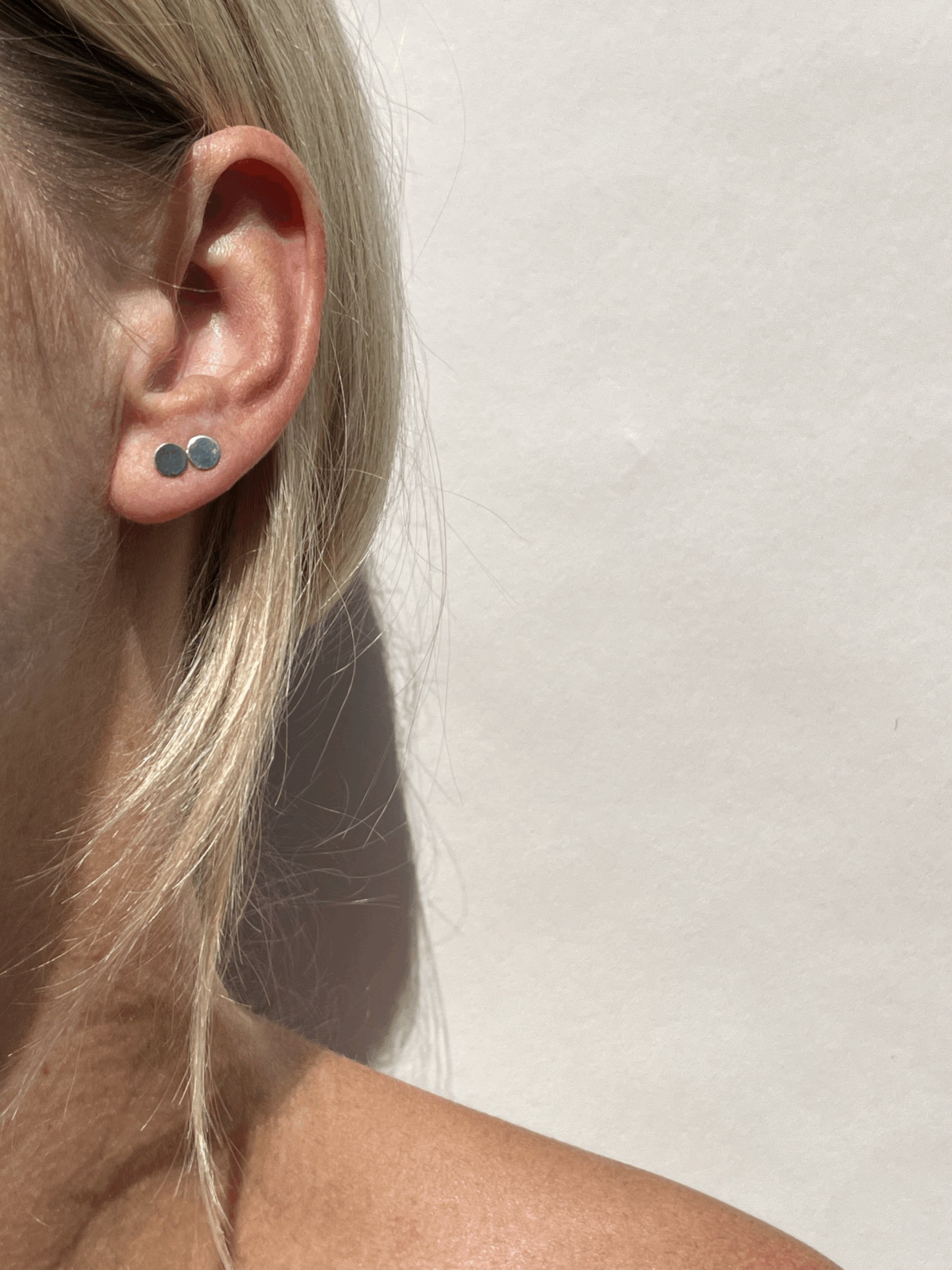 Model wearing a sterling silver circle stud in the first and second ear piercing