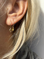 Model wearing Thalken 14k solid gold 12mm hoop earring with a small marquise-shaped citrine drop in the first ear piercing, and a 10mm hoop with a matching marquise citrine drop in the second piercing, showcasing minimalist fine jewelry styling