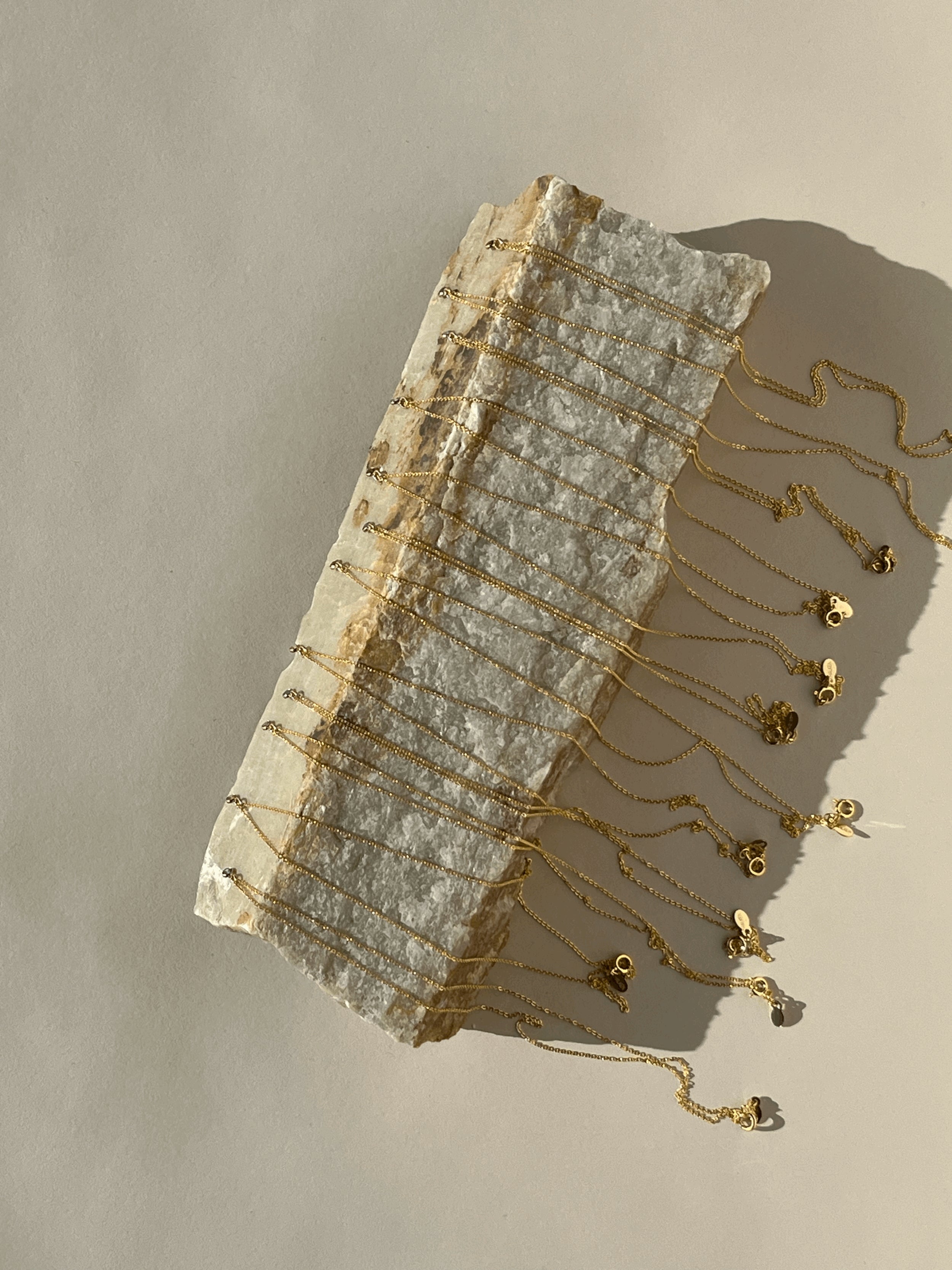 Bird’s-eye view of all 12 Thalken dainty birthstone necklace options with 3mm gold-filled cubic zirconia charms