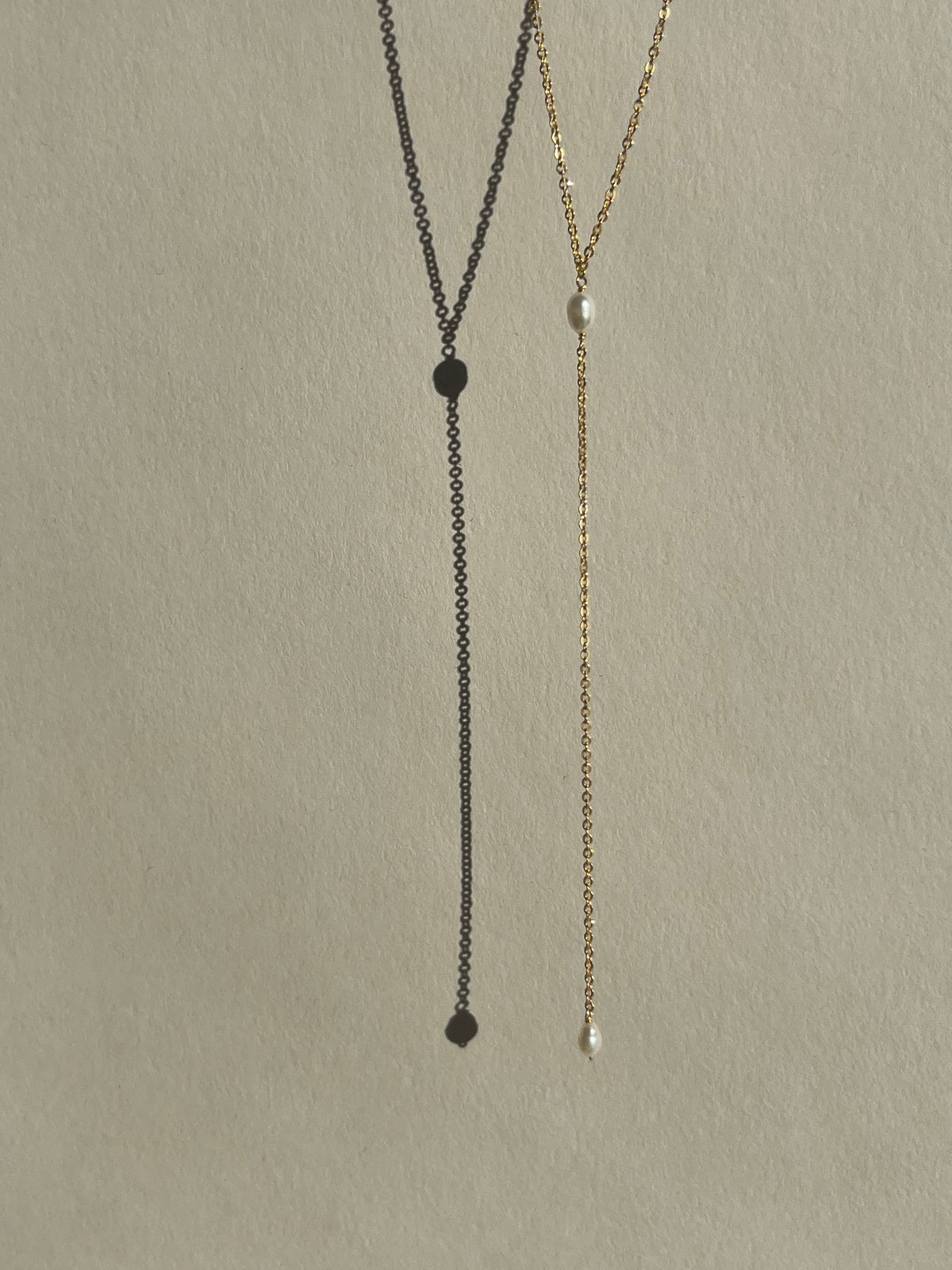 Dainty freshwater pearl lariat necklace from Thalken suspended in air, showcasing its minimalist and elegant design