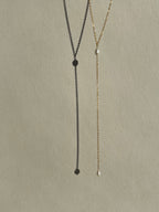 Dainty freshwater pearl lariat necklace from Thalken suspended in air, showcasing its minimalist and elegant design
