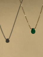 Thalken Emerald Drop Necklace with a green stone suspended in air