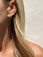 Model wearing 16mm sterling silver hoops in her first ear piercing and 14mm hoops in her second
