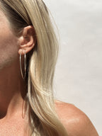 Side view of model showing 50mm sterling silver hoops in the first piercing and 40mm hoops in the second