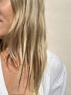 Model in white V-neck wearing 16” Original Medium Link Paperclip Necklace layered with 18” Minimalist Bead Chain Necklace, both yellow gold-filled