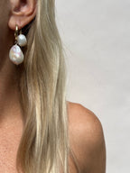 Model wearing the Grand Freshwater Pearl Drops in her first piercing and Medium Pearl Drop Threader Earrings in her second—both in yellow gold-filled