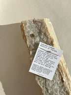 Pulled-back shot of bracelet on mantra bracelet card, styled on a rock surface