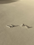 Two pairs of tiny Itty Bitty Crystal Stud earrings in sterling silver, shown in black cubic zirconia and clear cubic zirconia side by side on a neutral background