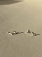 Two pairs of tiny Itty Bitty Crystal Stud earrings in sterling silver, shown in black cubic zirconia and clear cubic zirconia side by side on a neutral background