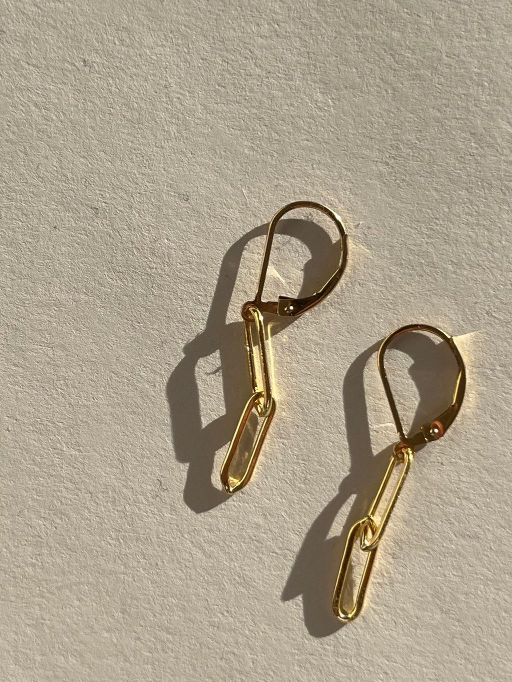 Close-up of the leverback clasp and connected paperclip links, showing the smooth gold-filled finish