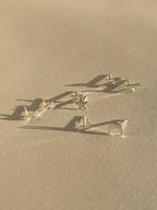 Four pairs of sterling silver stud earrings—lightning bolt, star, arrow, and moon—displayed together on a neutral background
