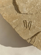 Overhead shot of long petite staple earrings in yellow gold-filled, positioned for a modern, minimalist presentation