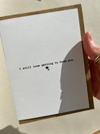 Hand holding Thalken A2 greeting card that reads “I still love getting to know you,” showing scale and minimalist design