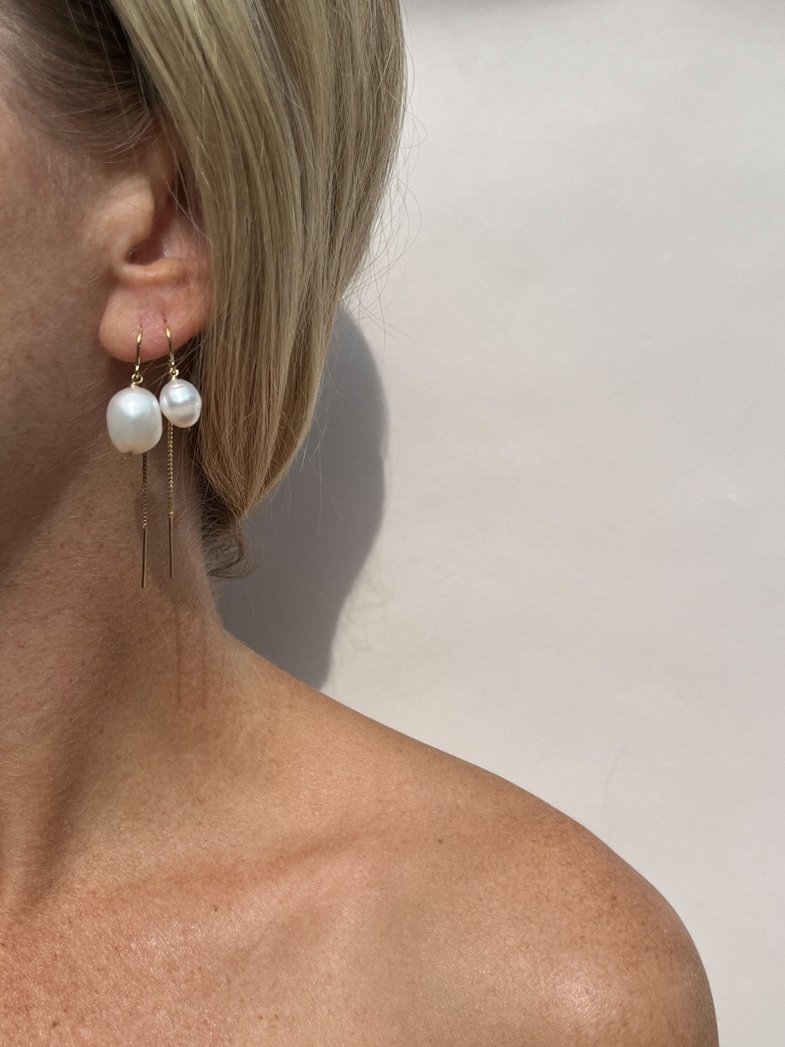 Model wearing the Medium Freshwater Pearl Drop Threader Earrings in her first piercing and Small Pearl Drop Threaders in her second—both in yellow gold-filled