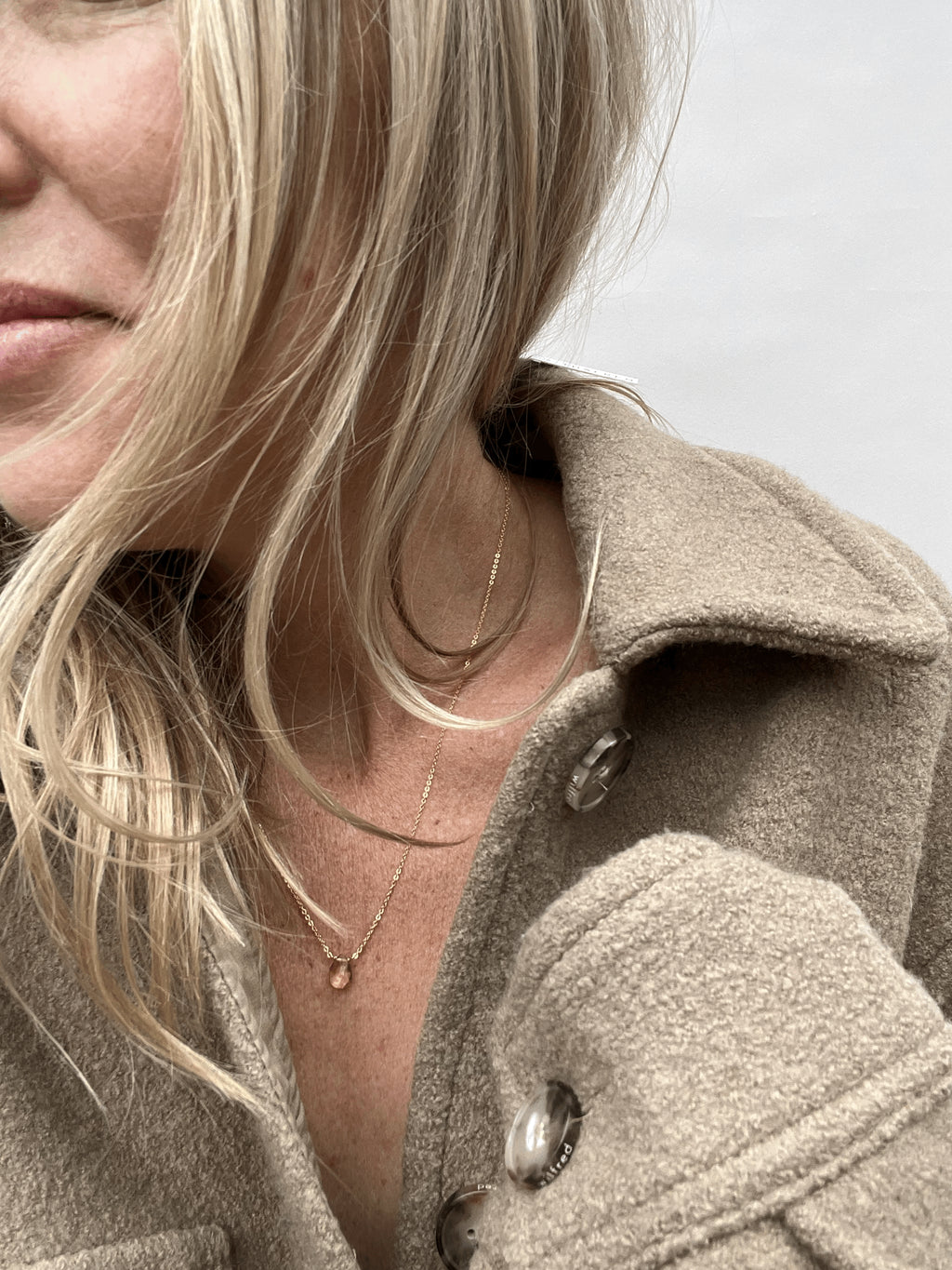 Model smiling while wearing a citrine drop necklace showcasing the jewelry