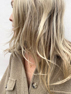 Model wearing a citrine drop necklace looking away from the camera