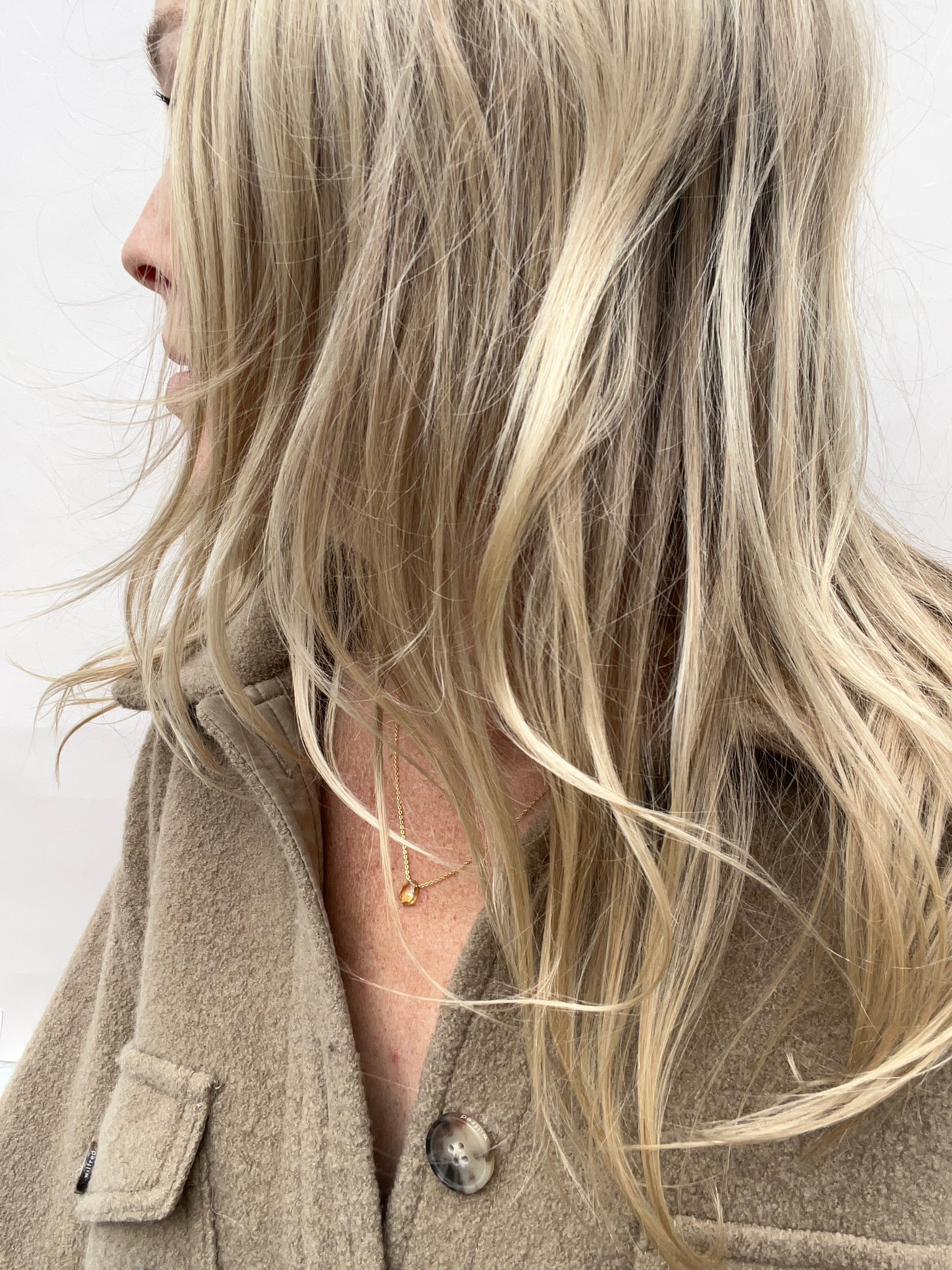 Model wearing a citrine drop necklace looking away from the camera