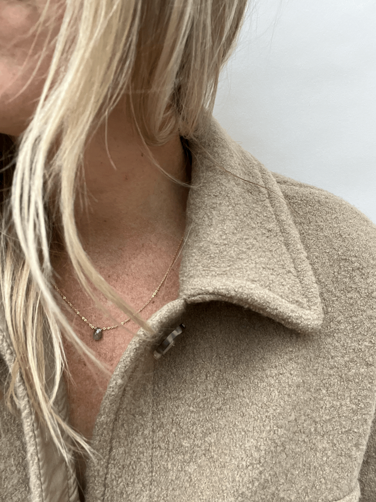 Model wearing dainty labradorite drop necklace in yellow gold-filled chain by Thalken