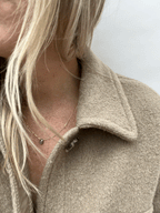 Model wearing dainty labradorite drop necklace in yellow gold-filled chain by Thalken