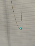 Close-up of yellow gold-filled dainty labradorite drop necklace on minimalist chain by Thalken