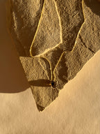 Yellow gold-filled minimalist smoky quartz necklace displayed on a top under warm lighting, highlighting the chain and natural gemstone