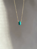 Minimalist turquoise drop necklace in yellow gold-filled, suspended in soft light with natural shadows highlighting the chunky gemstone