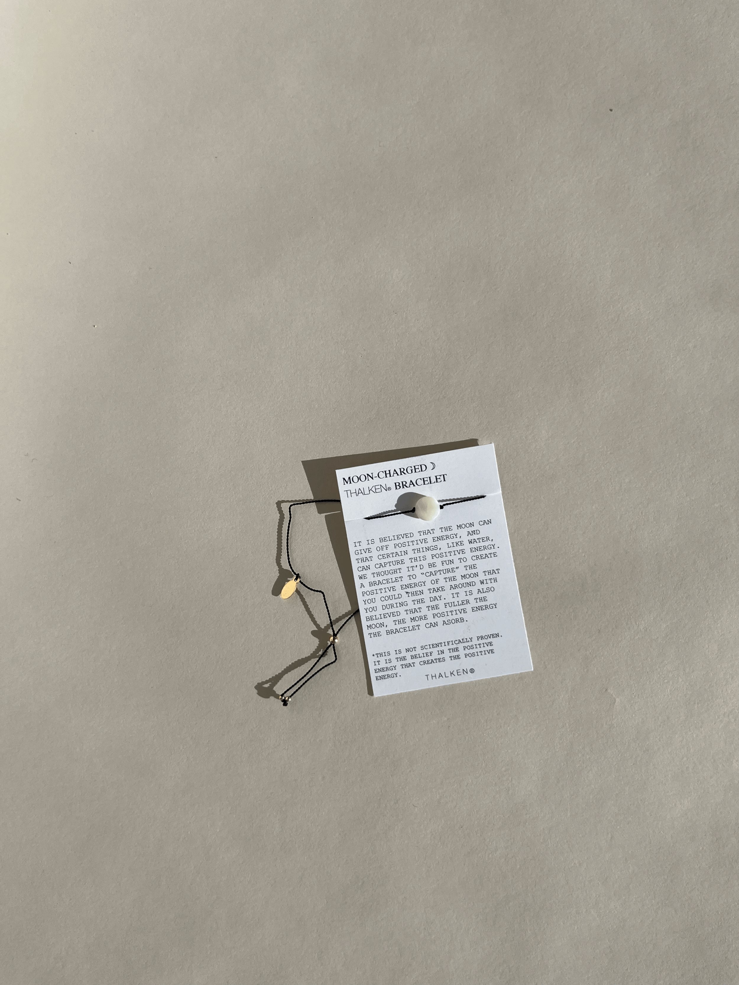 istance shot of the Moon Charged bracelet on its mantra card against a neutral backdrop