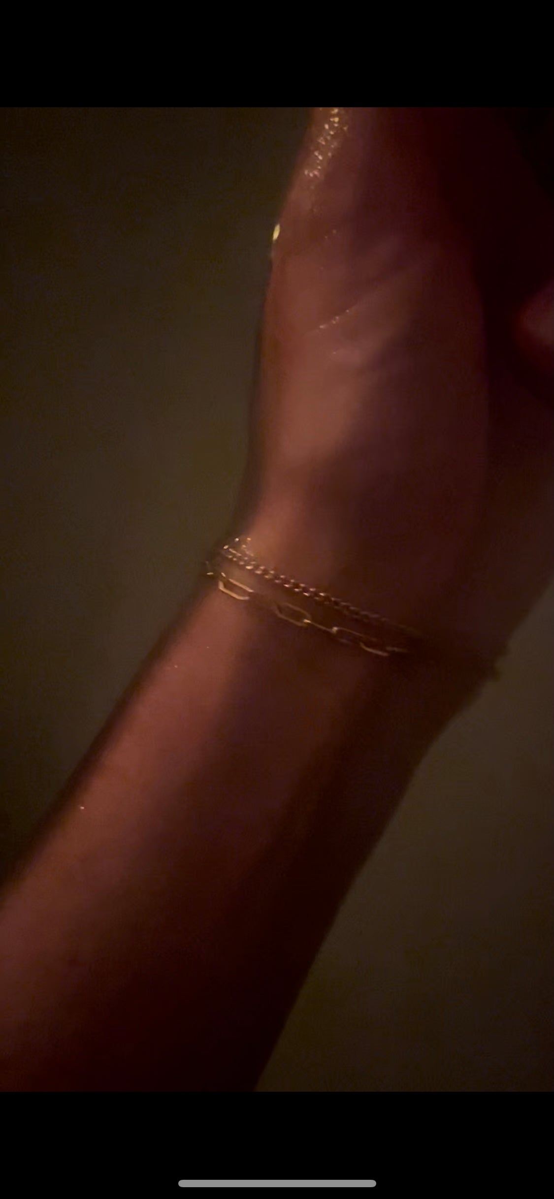 Thalken’s Small Link Paperclip Bracelet stacked with The Perfect Curb Chain Bracelet, worn on a wrist in a dark, romantic setting