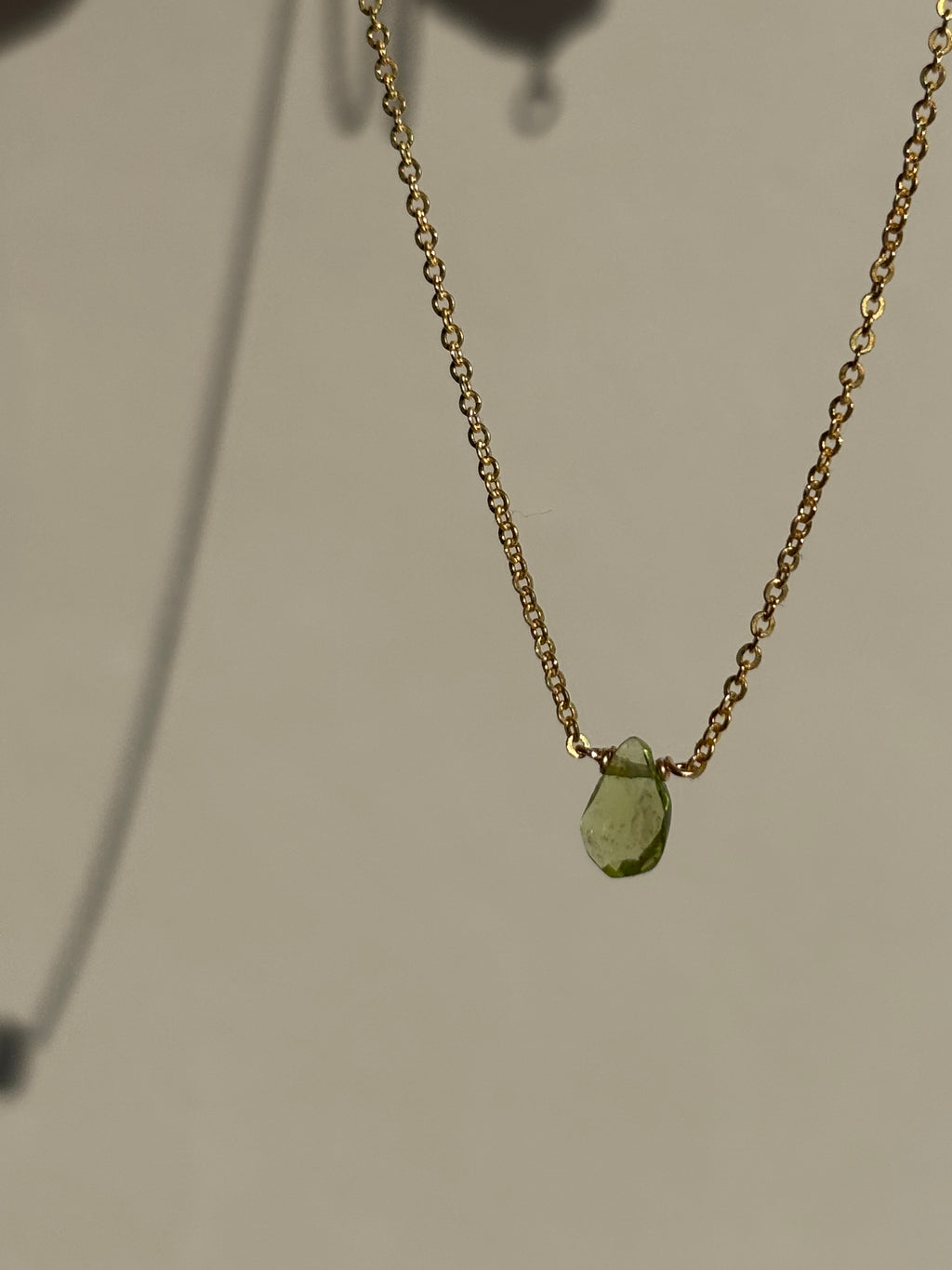 Peridot Drop Necklace against a neutral backdrop, shadow of necklace on the backdrop
