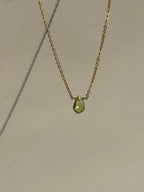 Peridot Drop Necklace suspended in air, showcasing the faceted peridot gemstone and delicate chain