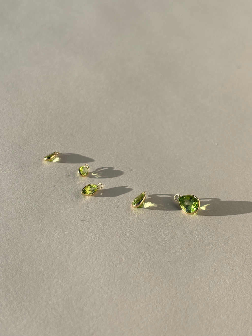 Loose single 14k gold drop earring charms in pear, marquise, and oval shapes, displayed in small, medium, and large sizes, shown unattached to hoops