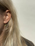 Model wearing a 12mm hoop with the medium oval drop in her first ear piercing, and a 10mm hoop with the small oval drop in her second ear piercing