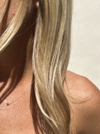 Blonde model wearing the sterling silver Petite Ball Choker necklace, styled in warm natural light for a soft, radiant look