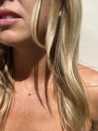 Close-up of model wearing the sterling silver Petite Ball Choker, mouth slightly open, highlighting the necklace’s elegant, minimalist design
